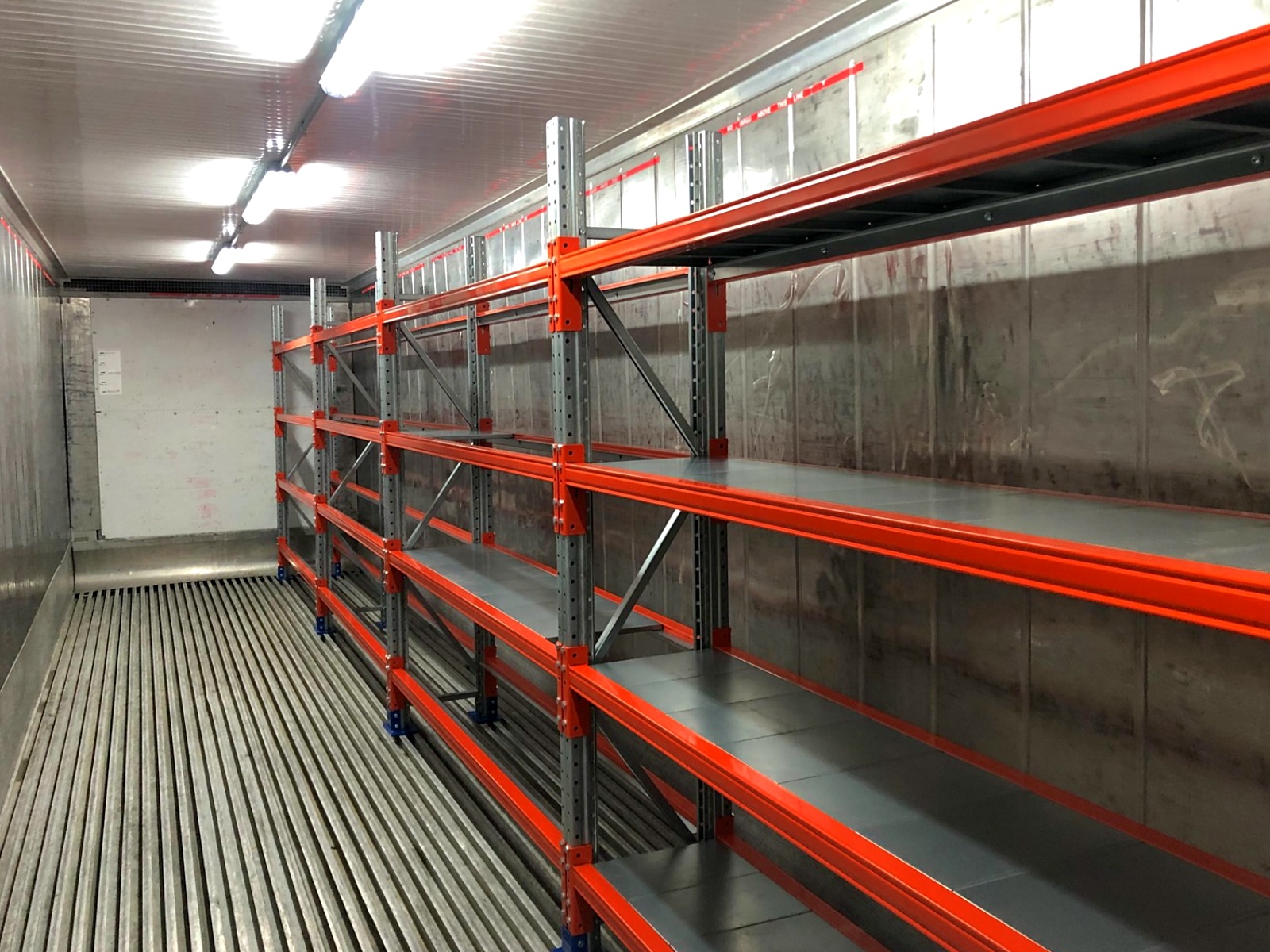 Racks de color naranja dentro de un recinto refrigerado